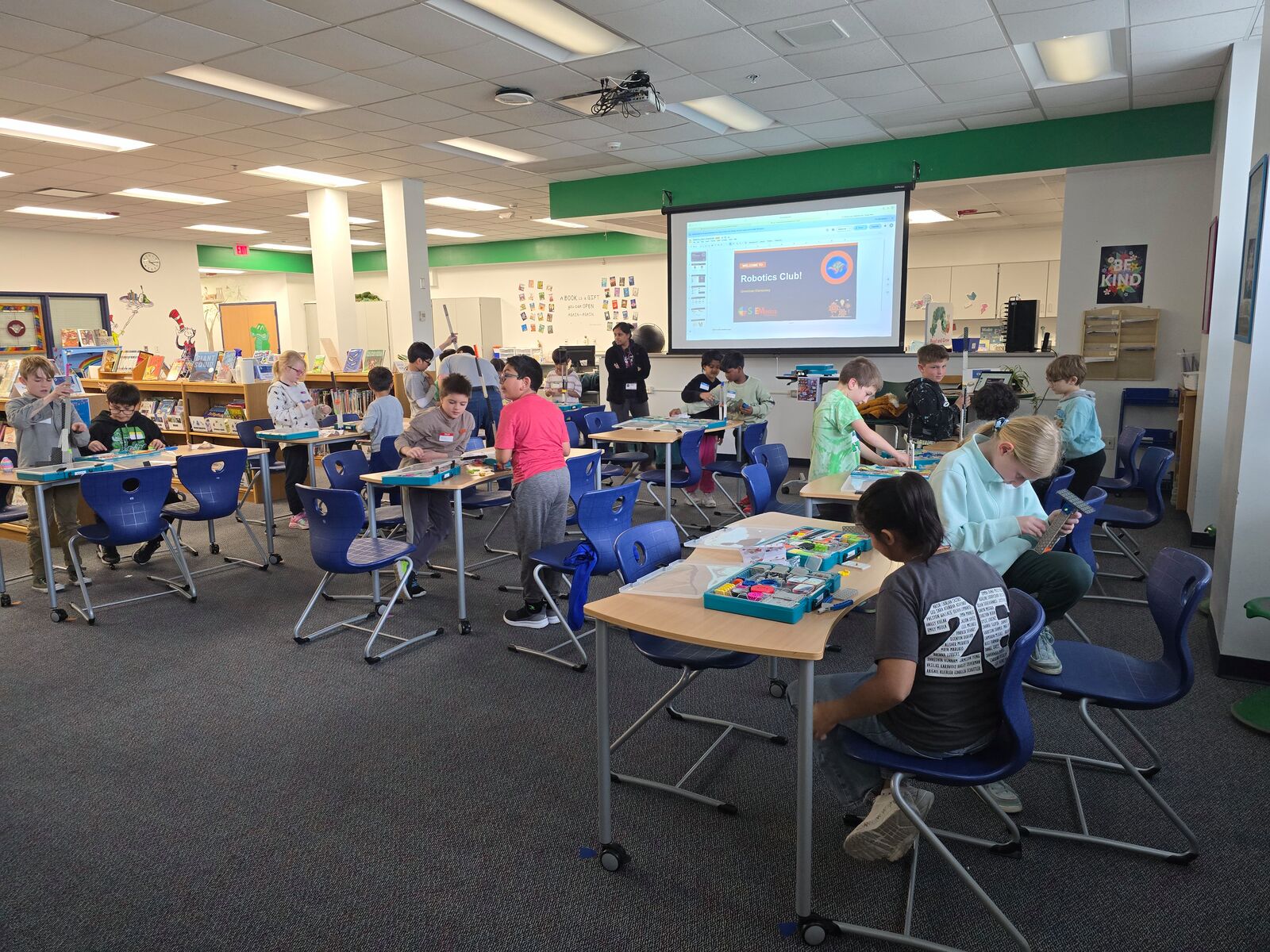 Students building robots at a Robotics Club session in a school library