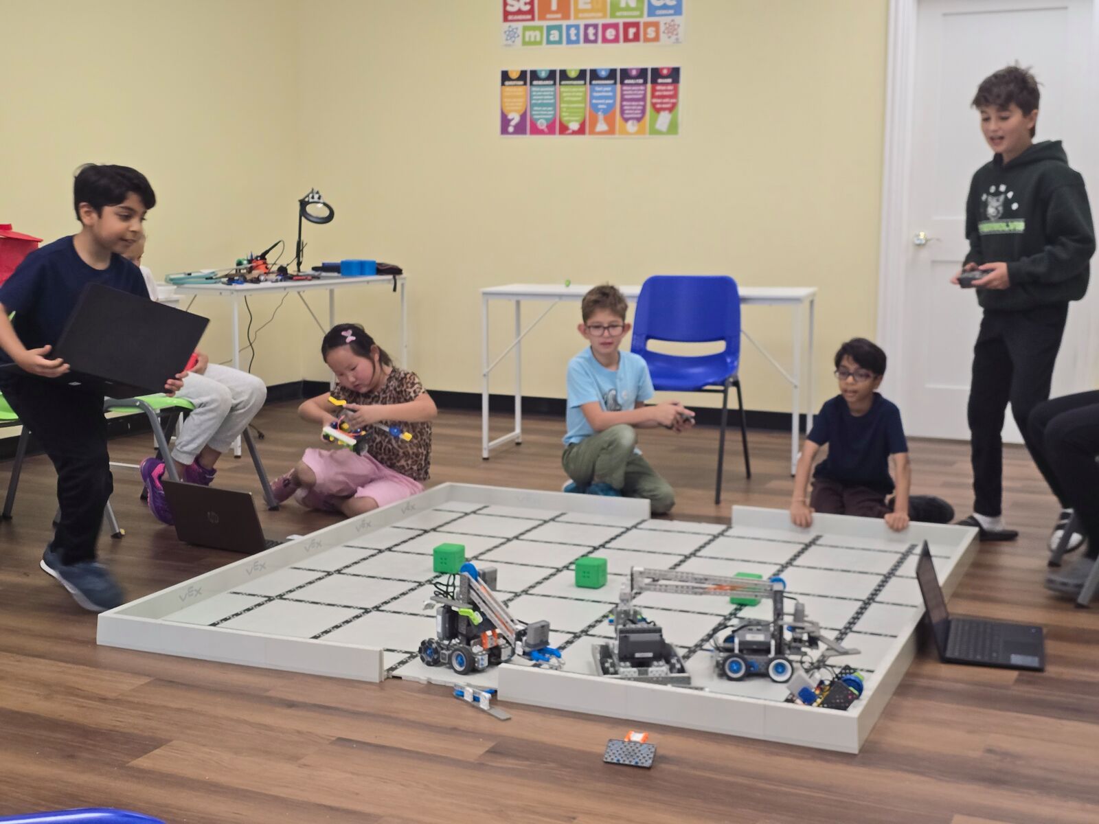 Students driving their robots on a VEX competition field